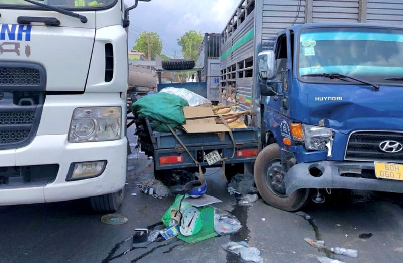 Xe ba gác bị kẹp giữa hai xe tải, bị hư hỏng, nhiều đồ đạc rơi ra ngoài. Xe ba gác bị kẹp giữa hai xe tải, bị hư hỏng, nhiều đồ đạc rơi ra ngoài.