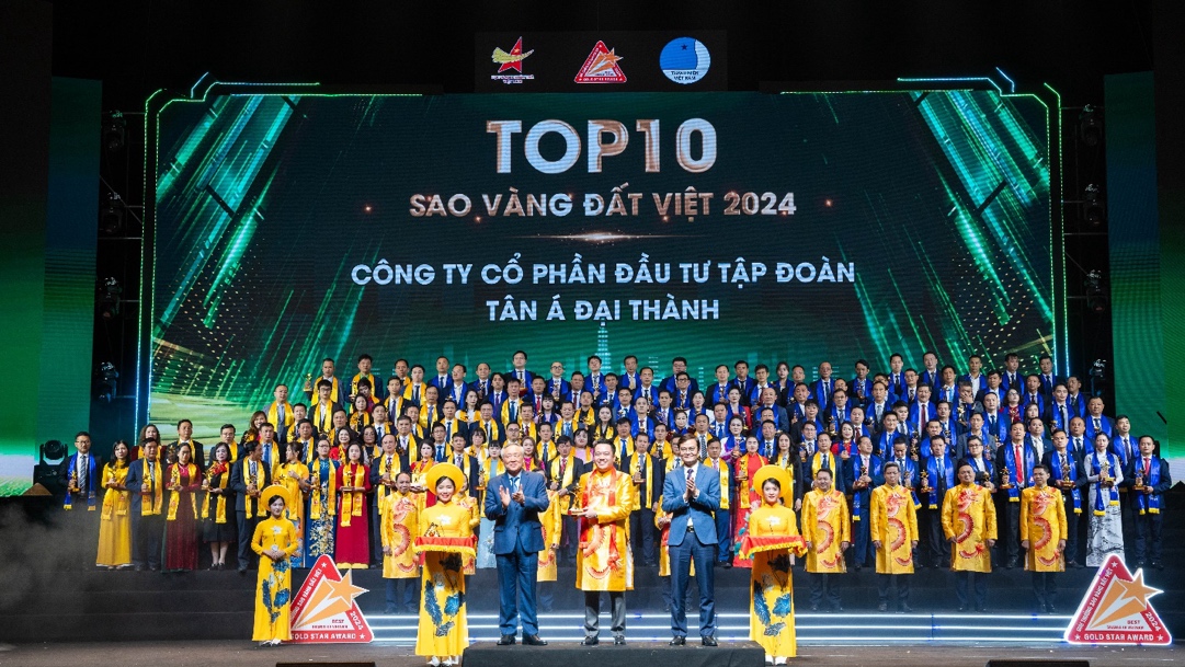 Tập đoàn Tân Á Đại Thành được vinh danh Top 10 Sao Vàng đất Việt- Ảnh 1. A group of people standing on a stage Description automatically generated